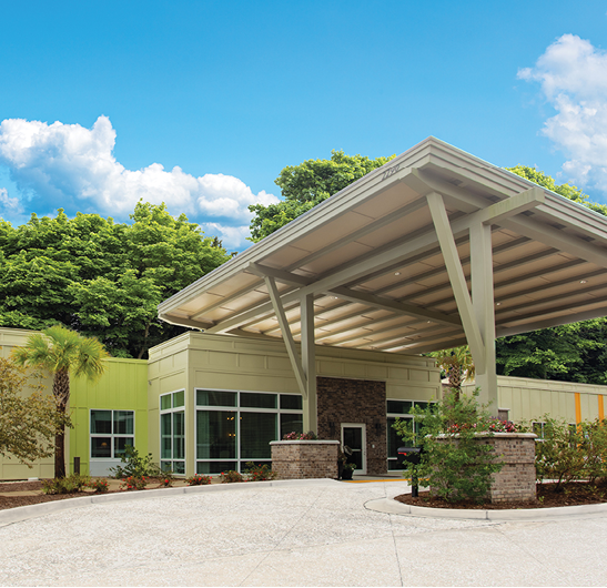 A large building with a covered entrance, a flag on a pole, and a bench in front of it. AI generated content