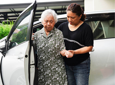 Caregiver help Asian elderly woman disability patient get in her car, medical concept.